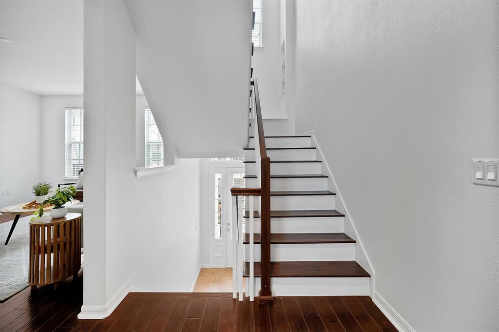 A staircase with dark wood treads and white risers leads to an upper level — 2018 BRINK ALLEY, ORLANDO, FL