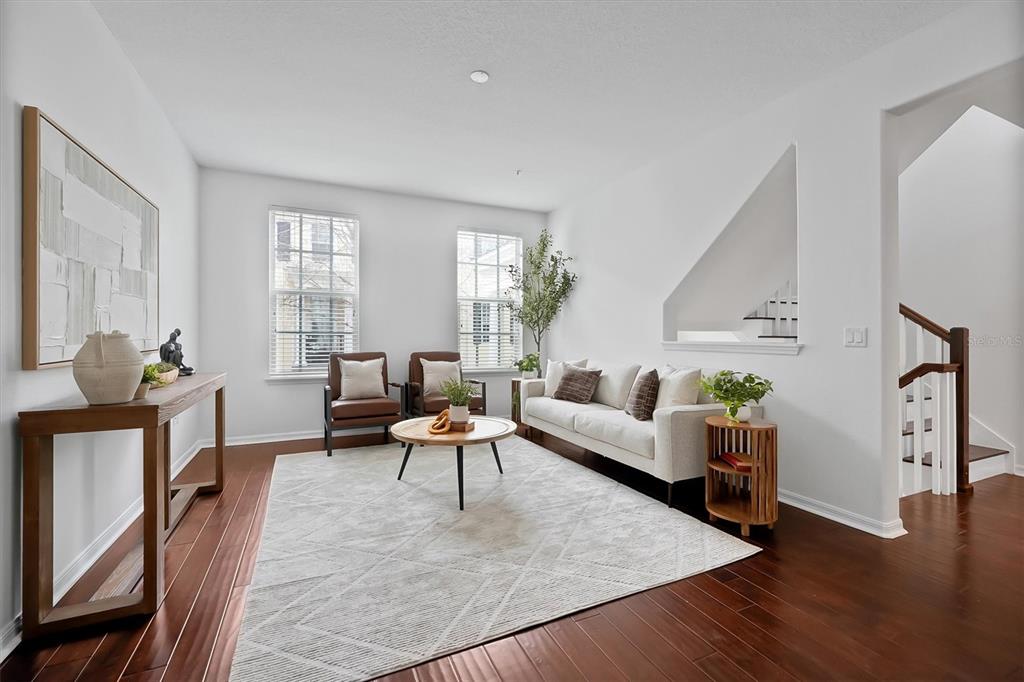 A living room features a white sofa, two brown chairs, a rug, and dark flooring — 2018 BRINK ALLEY, ORLANDO, FL