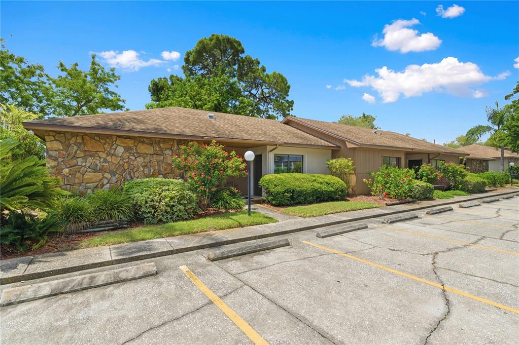 A single-story building with a stone facade and brown siding sits beside a parking lot — 10825 SEMINOLE BOULEVARD UNIT 1, LARGO, FL