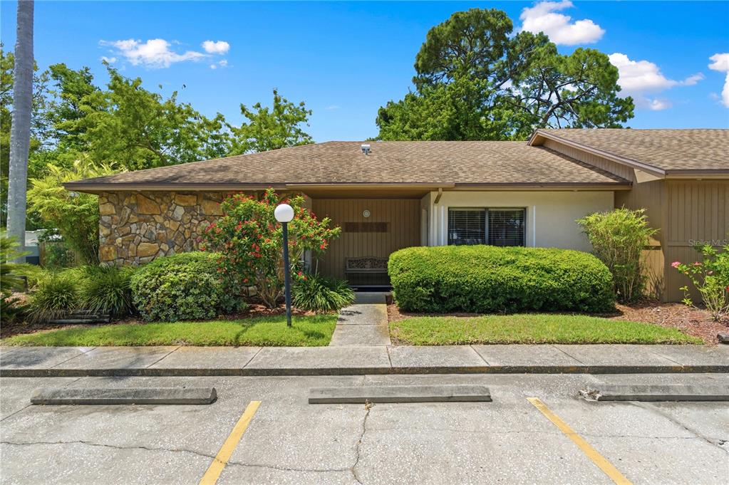 A single-story building with a stone facade, brown roof, and a landscaped front entrance — 10825 SEMINOLE BOULEVARD UNIT 1, LARGO, FL