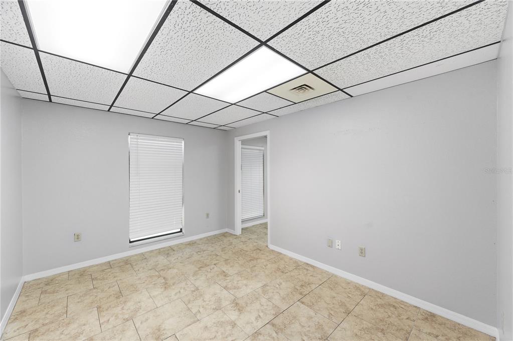 An empty office room with a drop ceiling, tile flooring, and light gray walls — 10825 SEMINOLE BOULEVARD UNIT 1, LARGO, FL