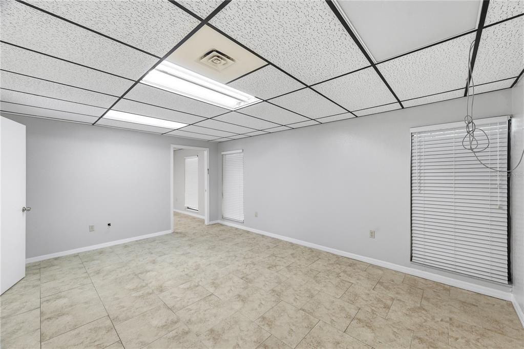 An empty room with gray walls, tile flooring, and a drop ceiling with recessed lighting — 10825 SEMINOLE BOULEVARD UNIT 1, LARGO, FL