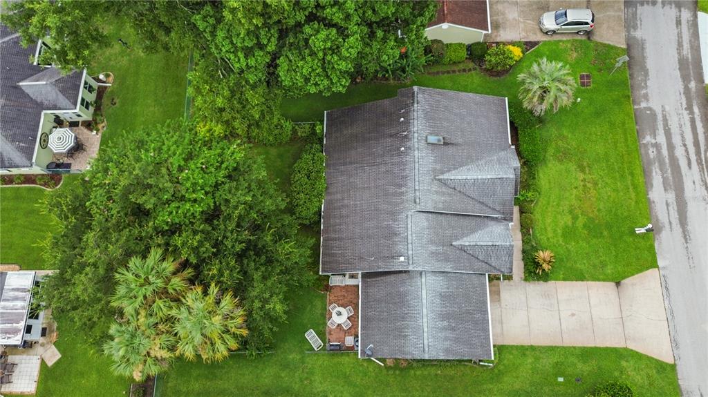 An aerial view shows a house with a gray roof, a driveway, and surrounding trees — 7734 SW 114TH LOOP, OCALA, FL