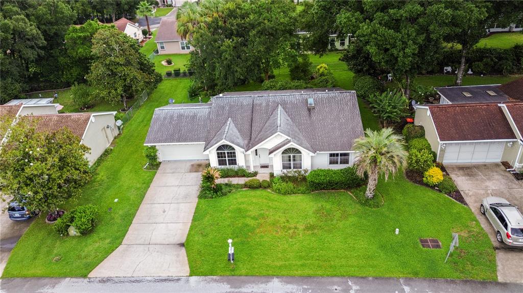 An aerial view of a single-story suburban house with a driveway and a front lawn — 7734 SW 114TH LOOP, OCALA, FL