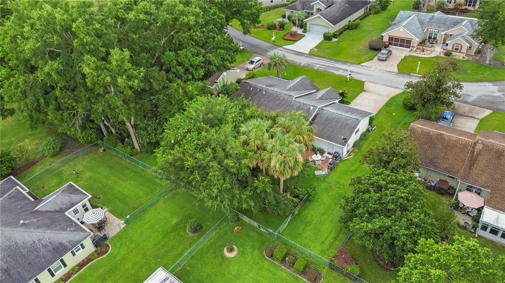 An aerial view shows several suburban houses with fenced backyards, green lawns, and mature trees — 7734 SW 114TH LOOP, OCALA, FL