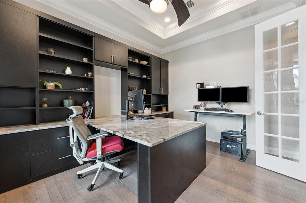 A home office features built-in black shelving, a stone-topped desk, and a standing desk — 13137 LOWER HARDEN AVENUE, ORLANDO, FL