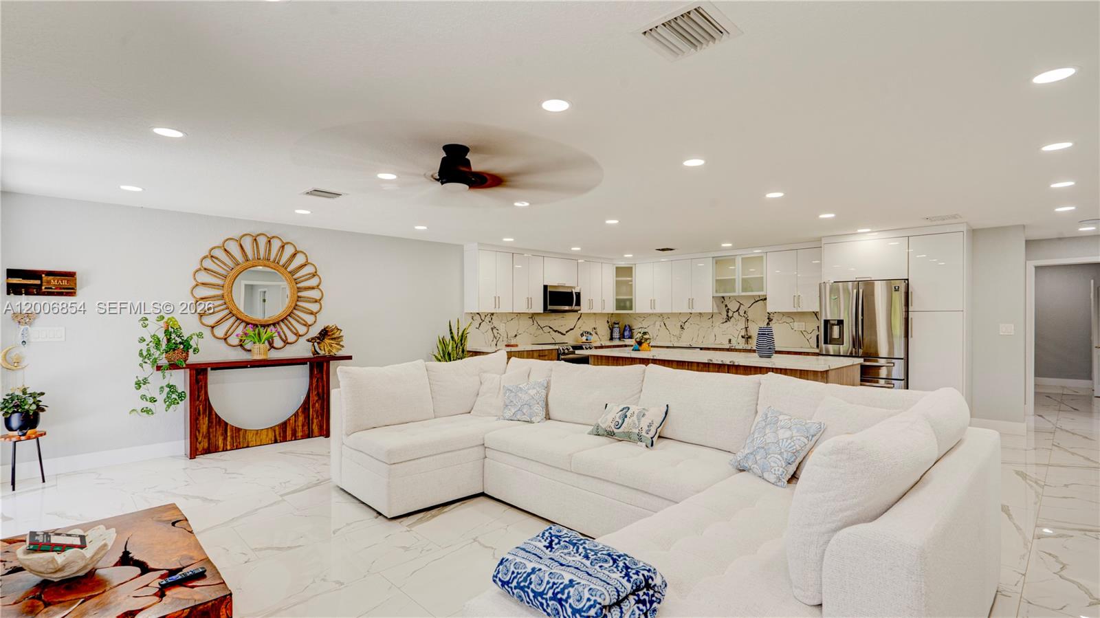 A modern open-concept living room features a white sectional sofa, marble floors, and a kitchen — 34 Atlantic Drive, Marathon FL 33037, MARATHON, FL