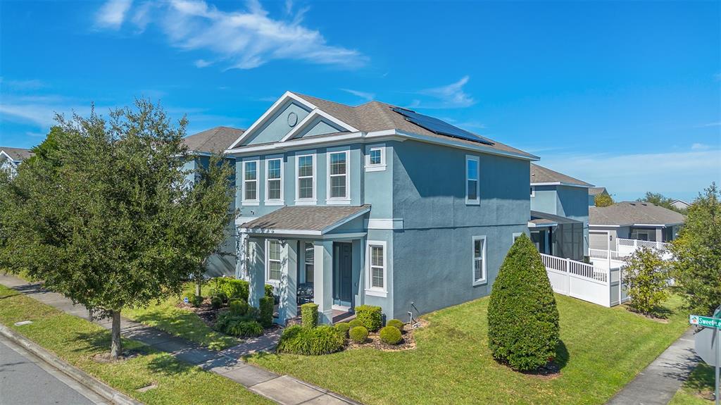 A two-story blue house with a front porch, solar panels, and a landscaped yard — 15807 SWEET LEMON WAY, WINTER GARDEN, FL