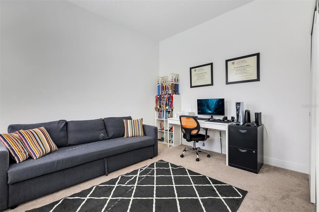 A home office features a gray sofa, a desk with a computer, and trophy shelving — 15807 SWEET LEMON WAY, WINTER GARDEN, FL