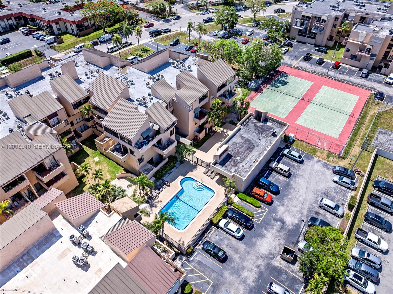 An aerial view shows a residential complex with a swimming pool, tennis court, and parking — 10500 SW 108th Ave # B211, Miami FL 33176, MIAMI, FL