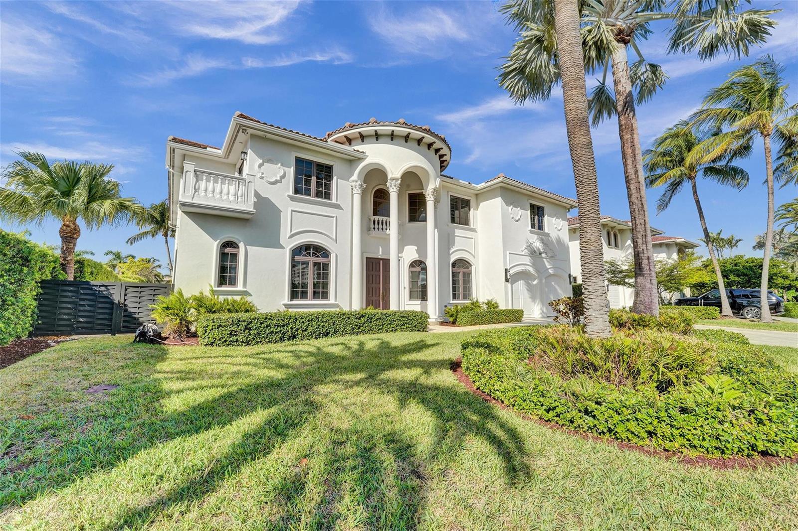 A two-story white Mediterranean-style house features a columned entryway, arched windows, and palm trees — 642 Palm Drive, Hallandale Beach FL 33009, HALLANDALE BEACH, FL