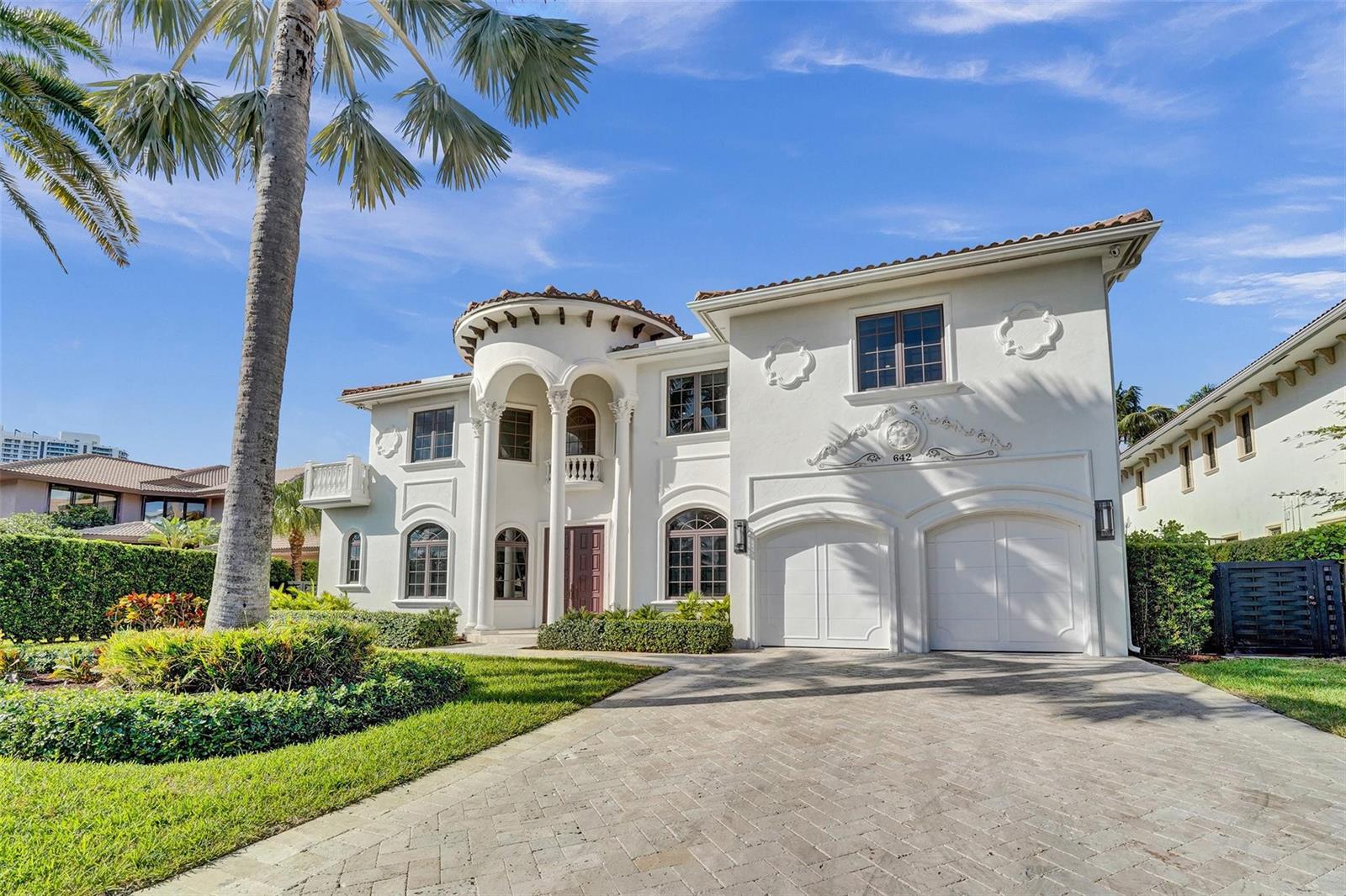 A two-story white Mediterranean-style house features a circular turret, arched windows, and a paved driveway — 642 Palm Drive, Hallandale Beach FL 33009, HALLANDALE BEACH, FL