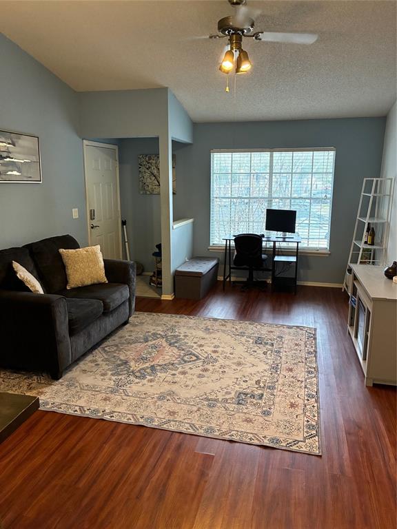 A living room features a dark sofa, a patterned area rug, and a desk area — 5433 LAKE MARGARET DRIVE UNIT E 195, ORLANDO, FL