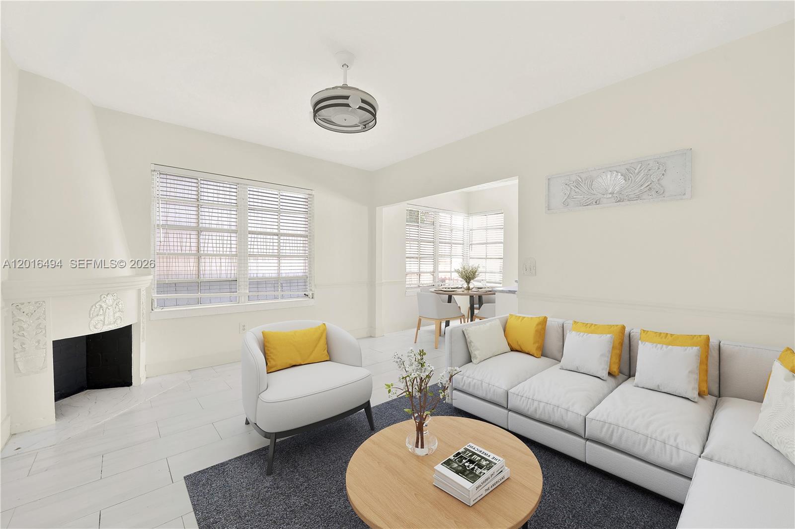 This living room features a fireplace, white tile flooring, and a sectional sofa — 610 8th St # 102, Miami Beach FL 33139, MIAMI BEACH, FL
