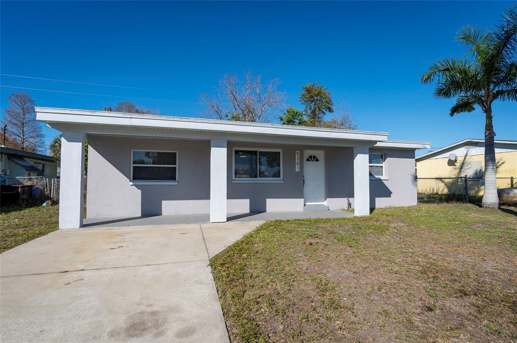 A single-story house with a gray exterior, a covered front porch, and a concrete driveway — 5301 97TH TERRACE N, PINELLAS PARK, FL