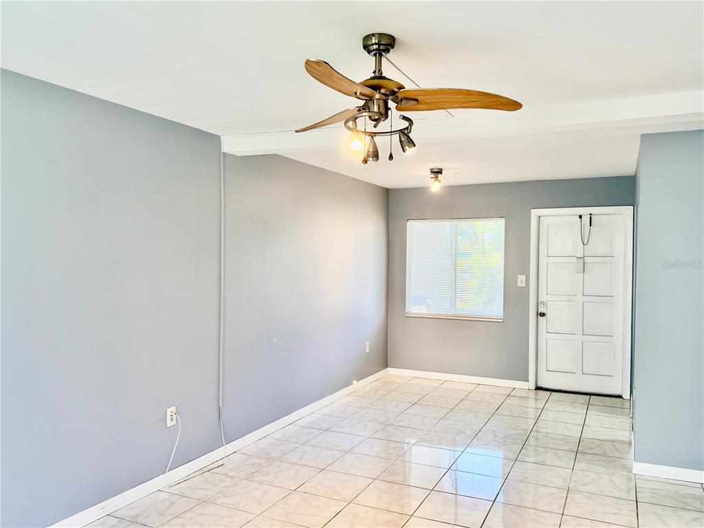 An empty room features light gray walls, white tile flooring, and a ceiling fan — 1825 FLAMINGO BOULEVARD UNIT O26, BRADENTON, FL