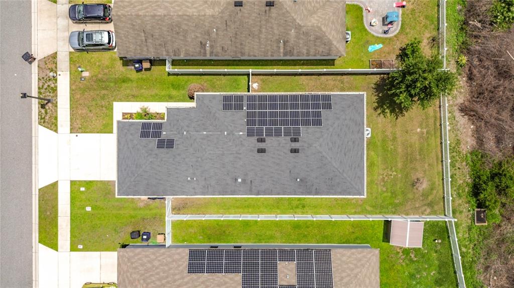 An aerial view shows two residential houses with solar panels installed on their roofs — 3040 LAKES CREST AVENUE, ST CLOUD, FL