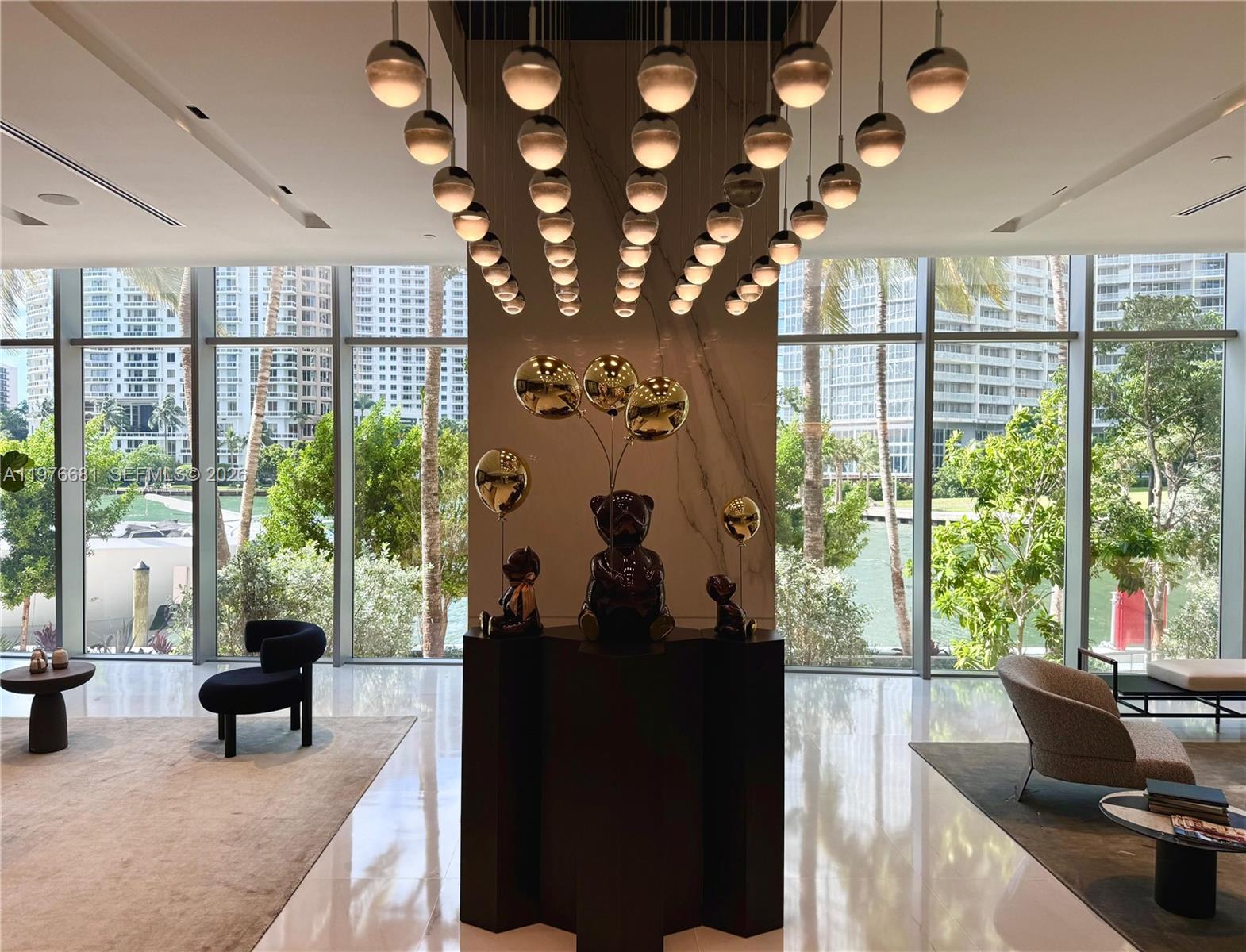 A modern lobby features a large bear sculpture, a tiered pendant light, and floor-to-ceiling windows — 300 Biscayne Boulevard Way # 3608W, Miami FL 33131, MIAMI, FL