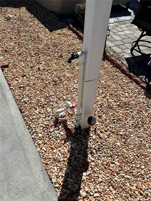 A white post with an attached outdoor water spigot stands in a gravel yard — 2920 FAIRWAY DRIVE, BOWLING GREEN, FL