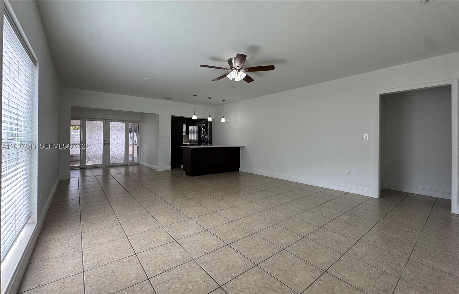 An open-concept living area features tile flooring, a ceiling fan, and a kitchen island — 7420 Big Cypress Dr, Miami Lakes FL 33014, MIAMI LAKES, FL