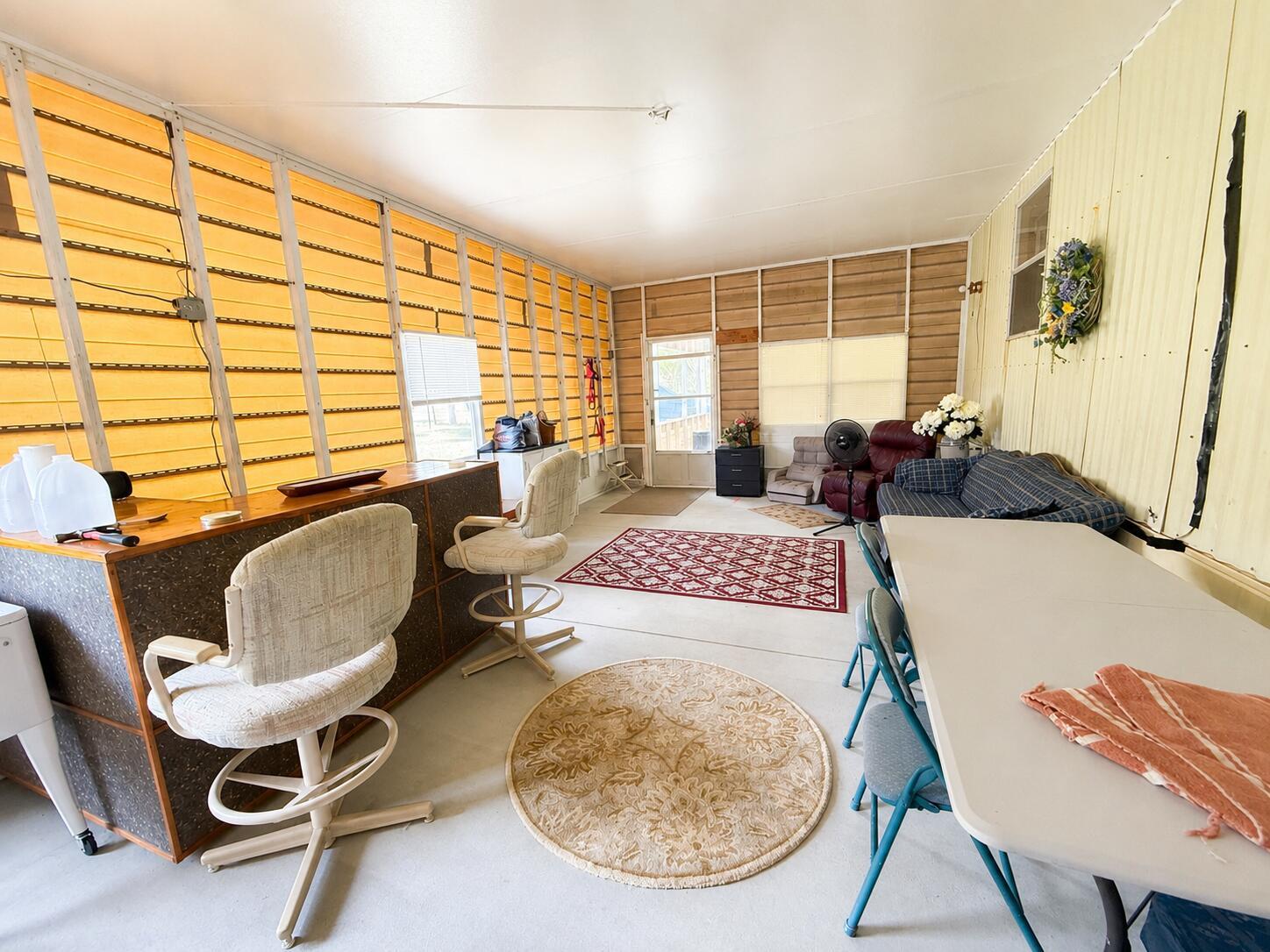 A sunroom features a bar with stools, a dining table, and a seating area — 482 Palmetto Avenue, FL 33935, FL