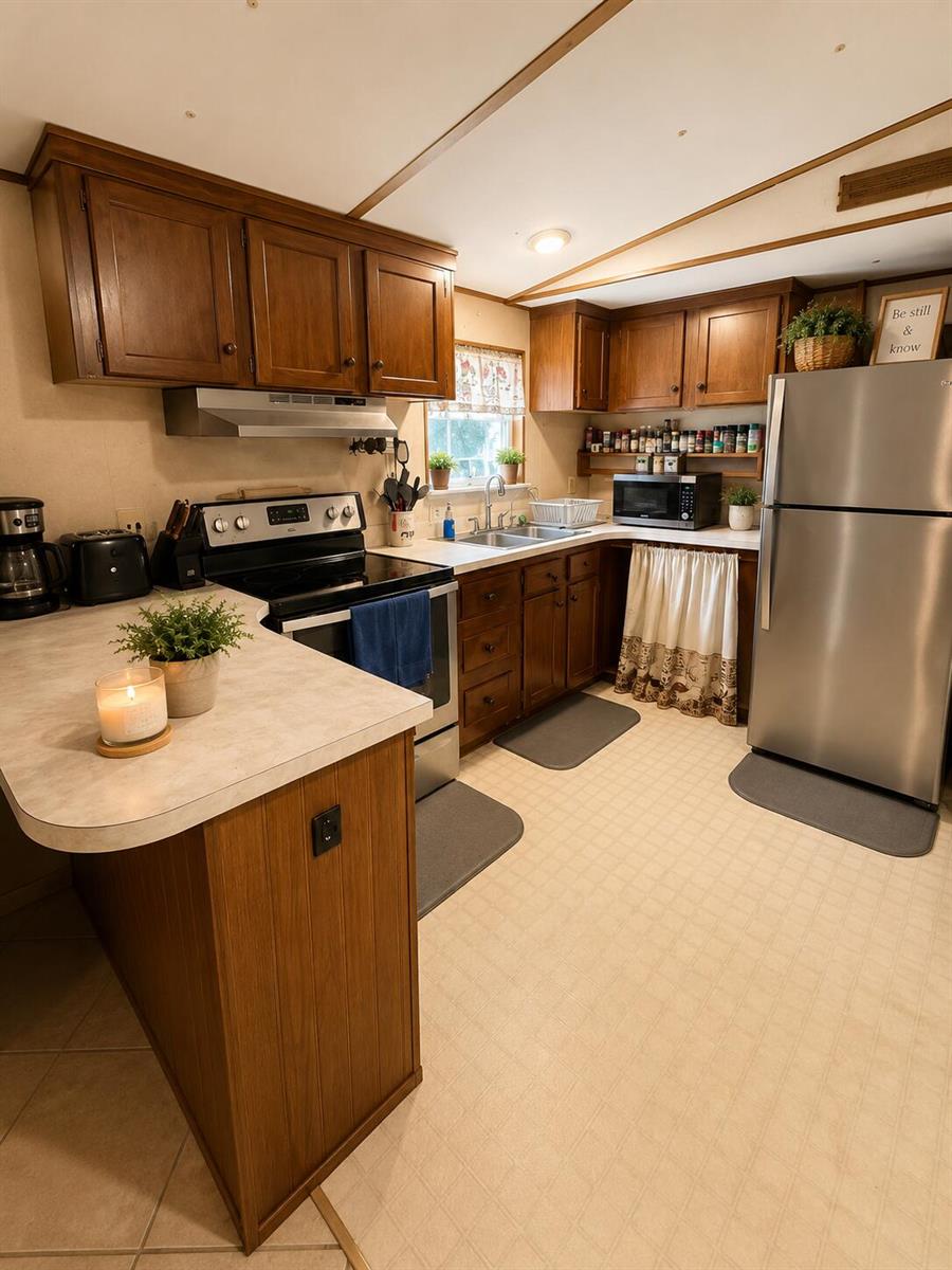 A kitchen features wood cabinets, stainless steel appliances, and a peninsula with a countertop — 482 Palmetto Avenue, FL 33935, FL