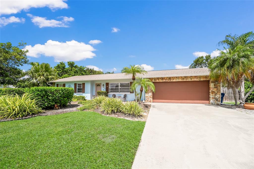 A single-story house with a light blue exterior, stone accents, and a two-car garage — 1004 68TH STREET NW, BRADENTON, FL