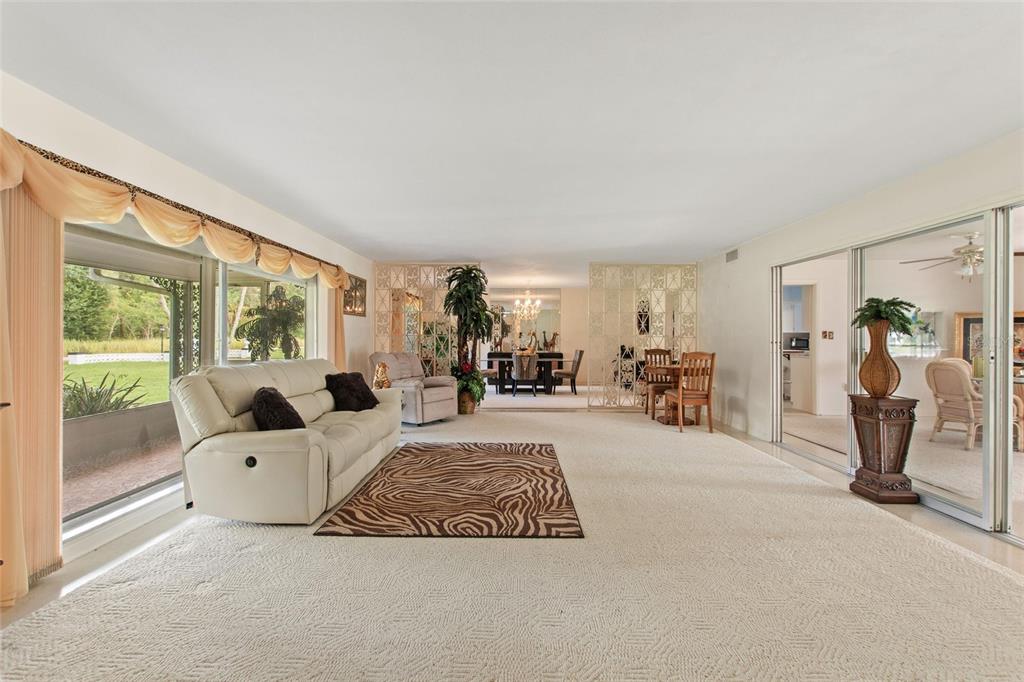 A living room features white sofas, a blue area rug, and a ceiling fan — 6197 AMARYLLIS DRIVE, INDIAN LAKE ESTATES, FL