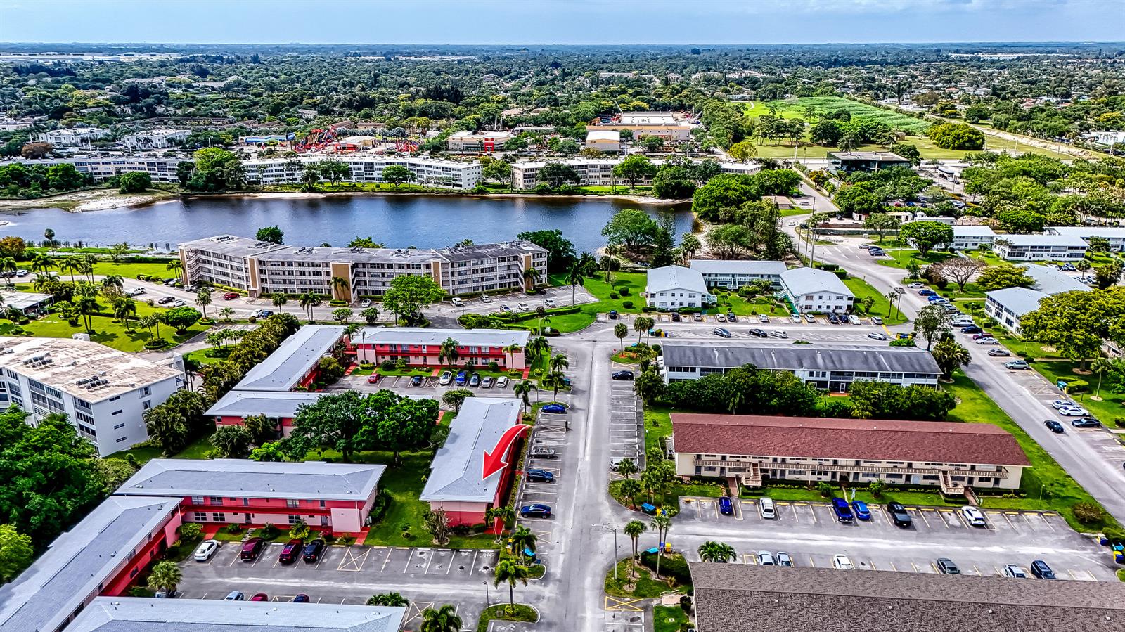 An aerial view shows a multi-story apartment complex with a red arrow pointing to a building — 24 Golfs Edge # D, West Palm Beach FL 33417, WEST PALM BEACH, FL