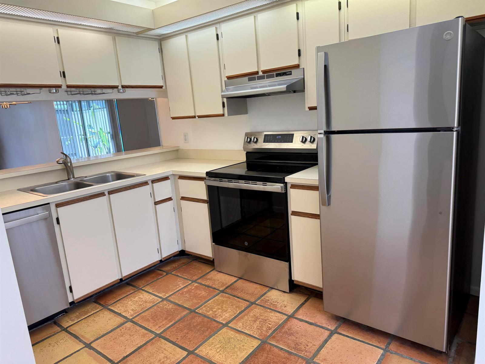 A kitchen with white cabinets, stainless steel appliances, and terracotta tile flooring — 6238 Riverwalk Lane # 7, Jupiter FL 33458, JUPITER, FL