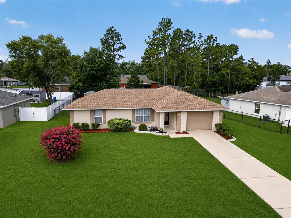 An aerial view of a single-story suburban house with a tan exterior and brown roof — 16 FIR TRAIL COURSE, OCALA, FL