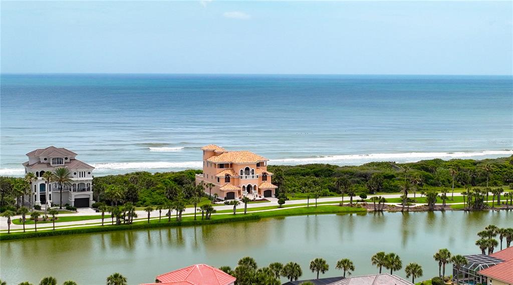 An aerial view shows two large houses situated between a lake and the ocean — 73 CALLE DEL SUR Lot 50, PALM COAST, FL