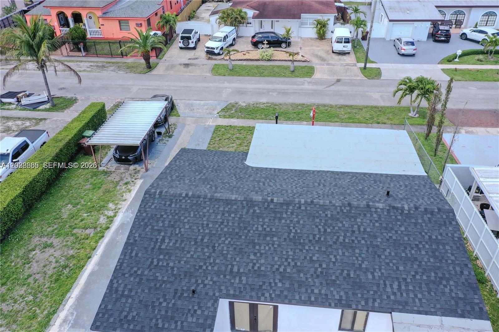 An aerial view shows a house with a shingled roof, carport, and adjacent street — 1014 W 66th St, Hialeah FL 33012, HIALEAH, FL