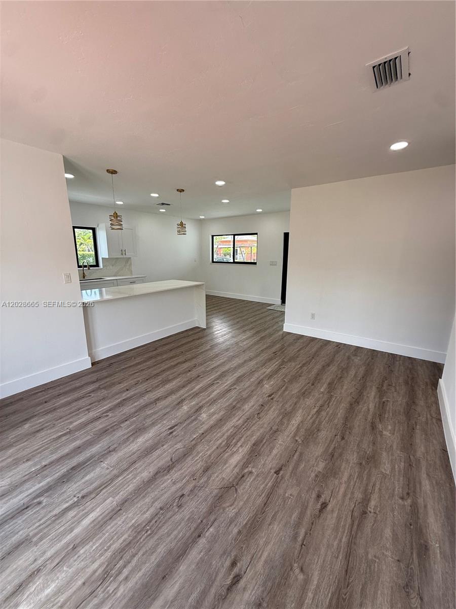 An open-concept living area features light-colored walls, recessed lighting, and wood-look flooring — 1014 W 66th St, Hialeah FL 33012, HIALEAH, FL