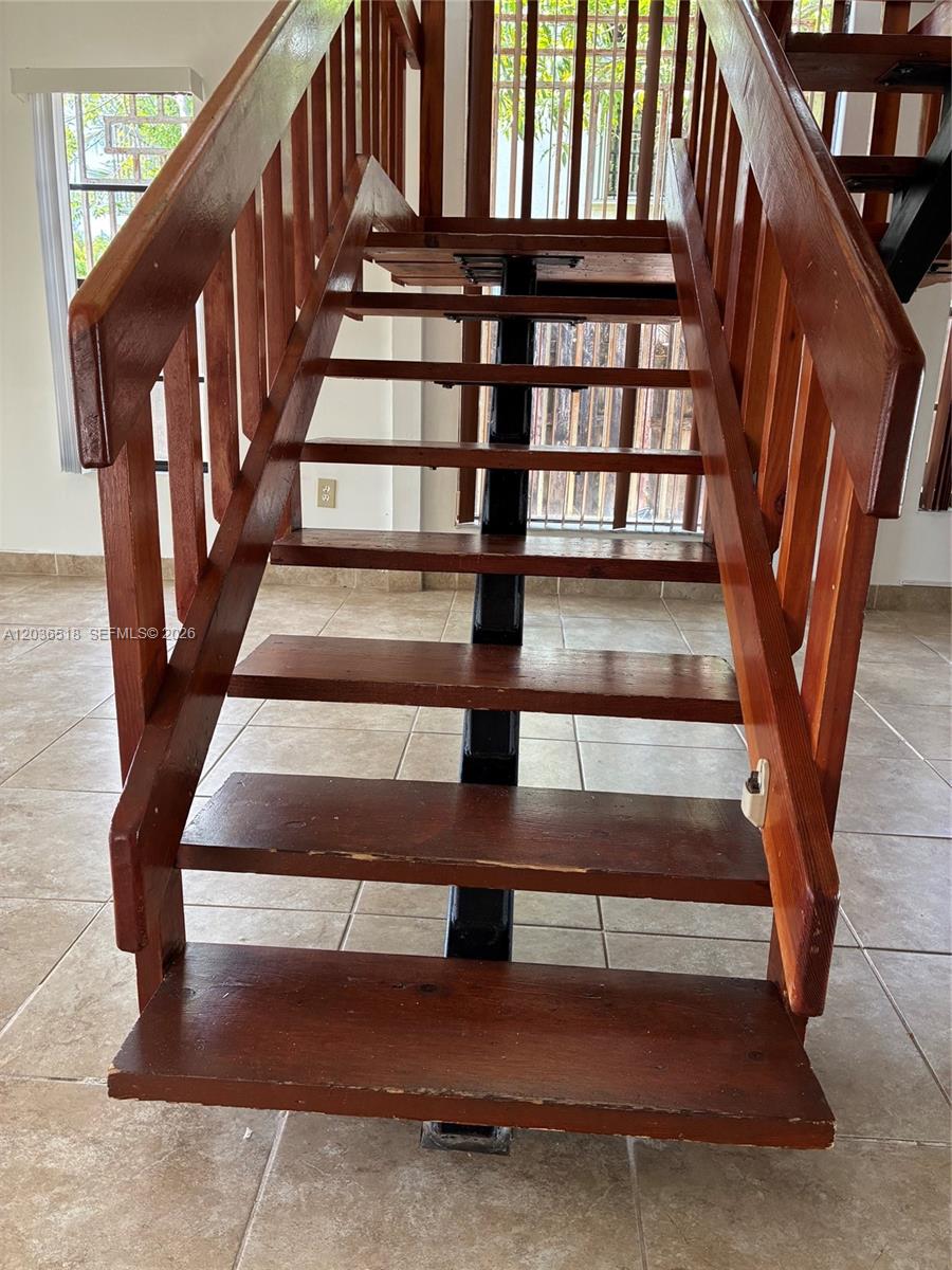 A wooden staircase with an open design and a central black metal support beam — 2441 SW 111th Ave # 2441, Miami FL 33165, MIAMI, FL