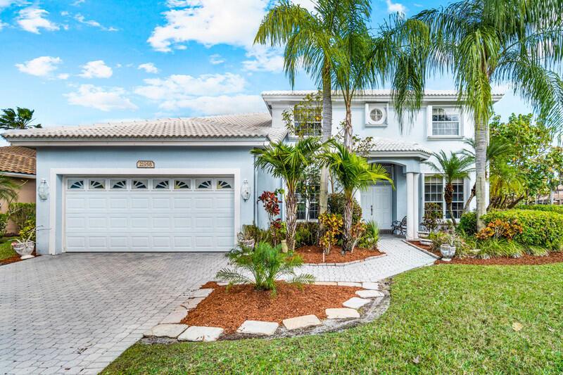 A two-story light blue house with a white garage door and palm trees in front — 21958 Palm Grass Drive, Boca Raton FL 33428, BOCA RATON, FL