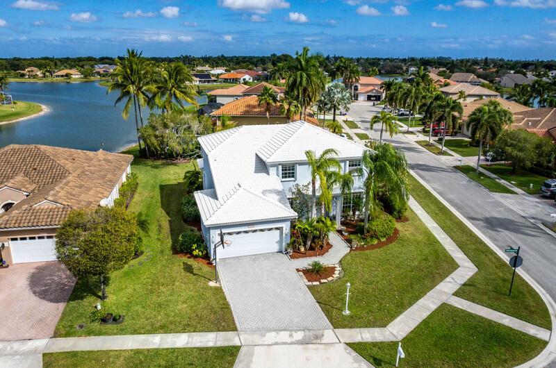 An aerial view of a two-story house with a white roof and a paved driveway — 21958 Palm Grass Drive, Boca Raton FL 33428, BOCA RATON, FL