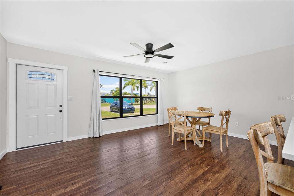 A dining area with wood-look flooring, a ceiling fan, and a view of a parked car — 410 W GRACE STREET, PUNTA GORDA, FL
