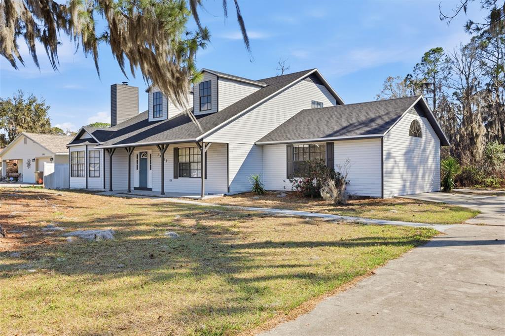 A two-story house with white siding, a dark roof, and a front porch — 33710 LINDA LANE, LEESBURG, FL