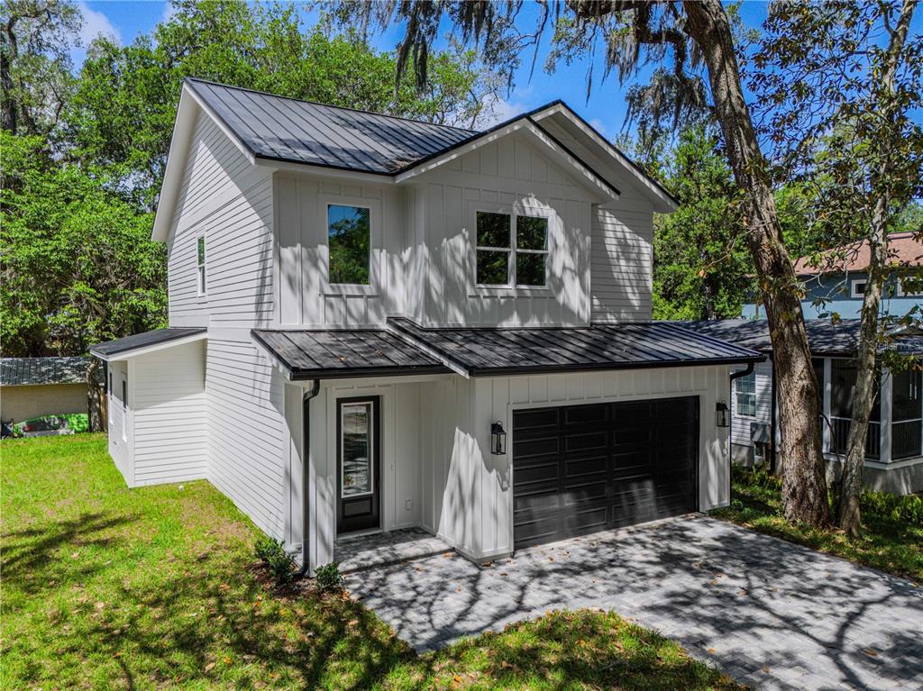 A two-story white house with a black metal roof and a two-car garage — 2 SANCHEZ AVENUE, PALM COAST, FL