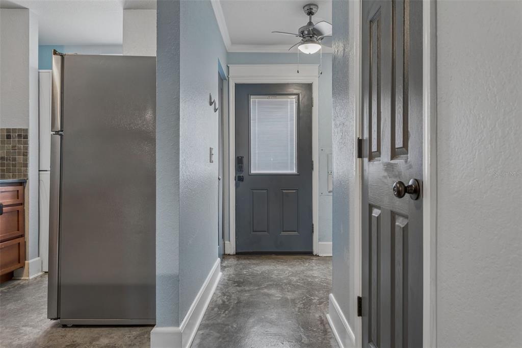 A hallway with light blue walls, a dark gray door, and a dark gray interior door — 5720 DALDEN DRIVE UNIT 5720, TAMPA, FL