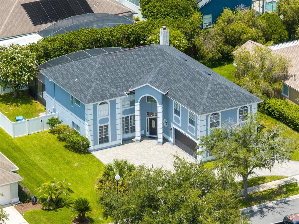 An aerial view of a two-story blue house with a gray shingled roof and driveway — 224 HAMMOCK DUNES PLACE, ORLANDO, FL