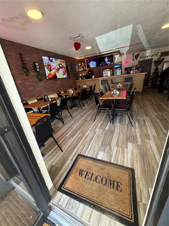 An interior view of a restaurant featuring a brick wall, wooden tables, and a bar — 36657 US HIGHWAY 19 N, PALM HARBOR, FL
