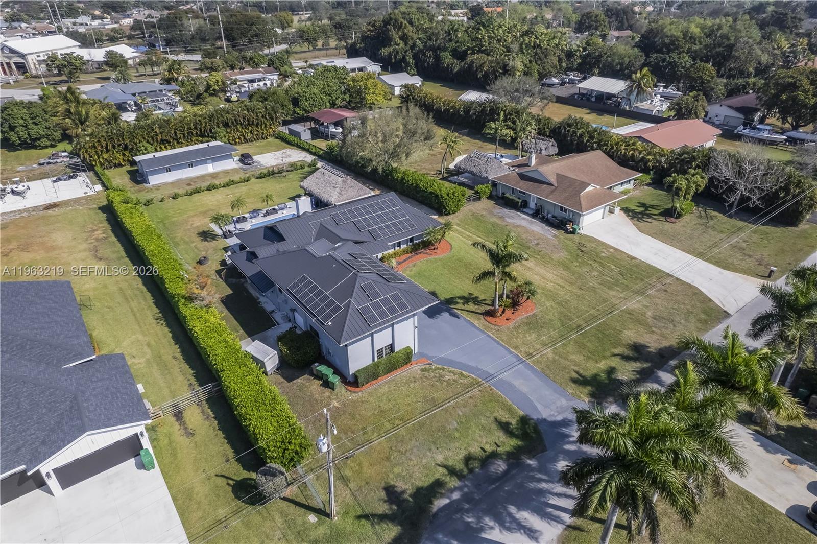 An aerial view shows a house with solar panels, a pool, and palm trees — 14651 SW 16th St, Davie FL 33325, DAVIE, FL