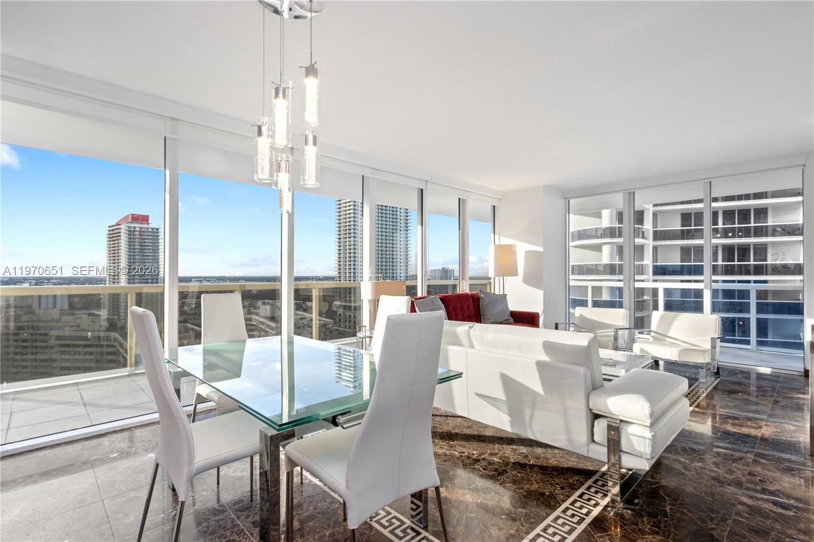 A modern living and dining area features floor-to-ceiling windows, marble flooring, and city views — 1830 S Ocean Dr # 1908, Hallandale Beach FL 33009, HALLANDALE BEACH, FL