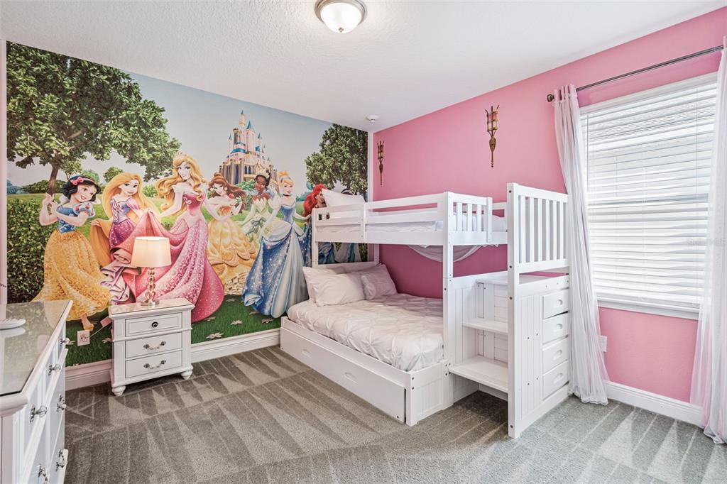 A child's bedroom features a Disney princess mural, white bunk beds, and pink walls — 7649 FAIRFAX DRIVE, KISSIMMEE, FL
