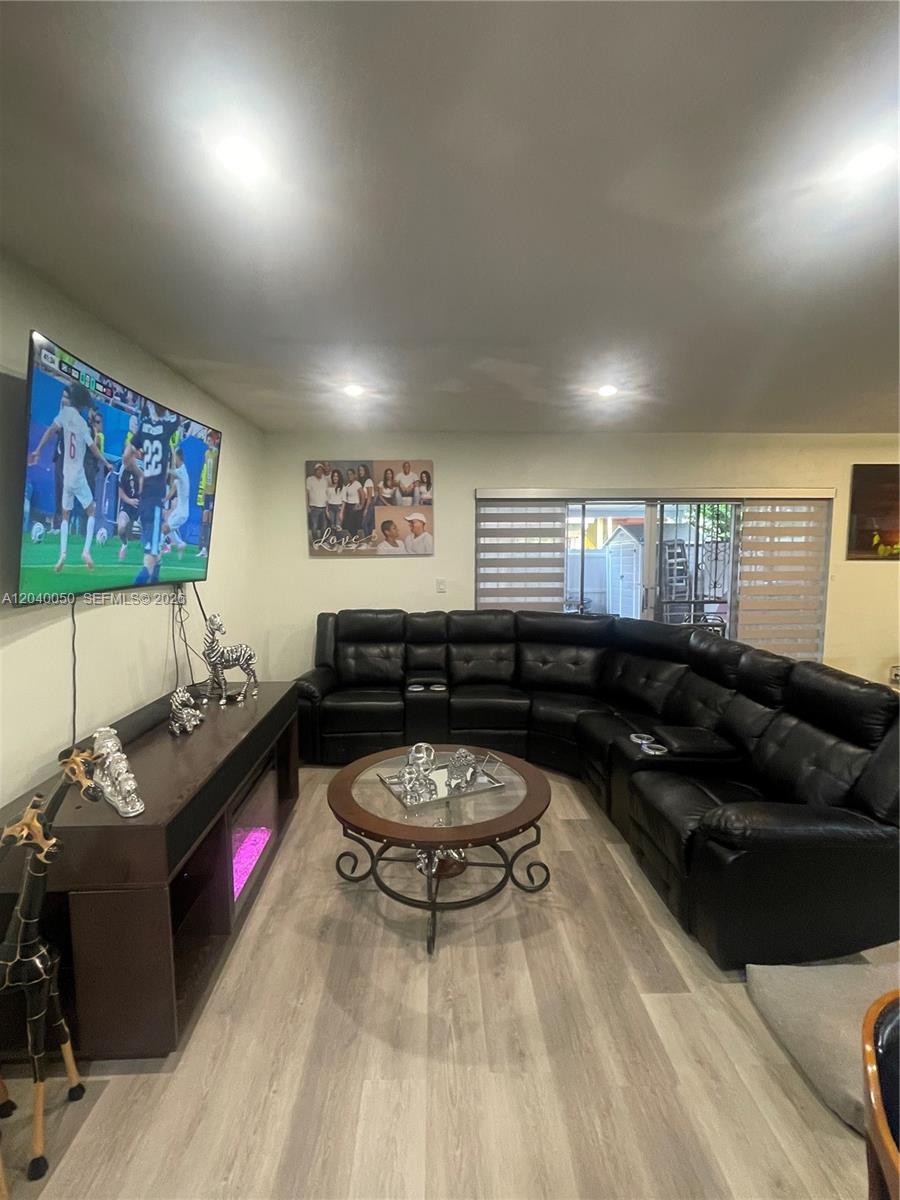 A living room features a large black sectional sofa, a television, and a coffee table — 6945 W 2nd Way, Hialeah FL 33014, HIALEAH, FL