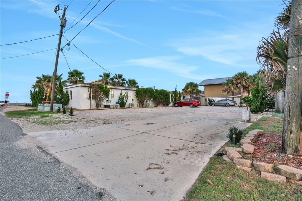 A gravel and concrete parking lot sits in front of a single-story residential building — 111 S 12TH STREET, FLAGLER BEACH, FL