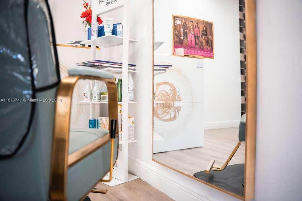 A salon station features a styling chair, a product display shelf, and a large mirror — 825 E COWBOY WAY, La Belle FL 33935, LA BELLE, FL
