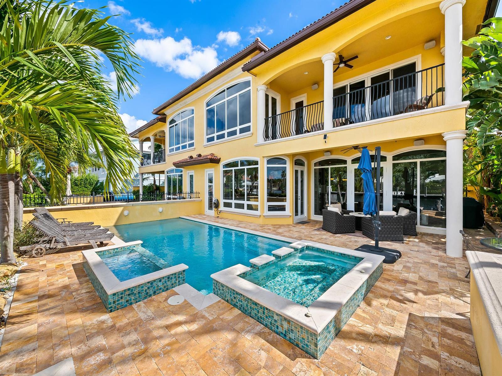 A yellow two-story house features a swimming pool, two spas, and a stone patio — 2637 NE 28th Court, Lighthouse Point FL 33064, LIGHTHOUSE POINT, FL